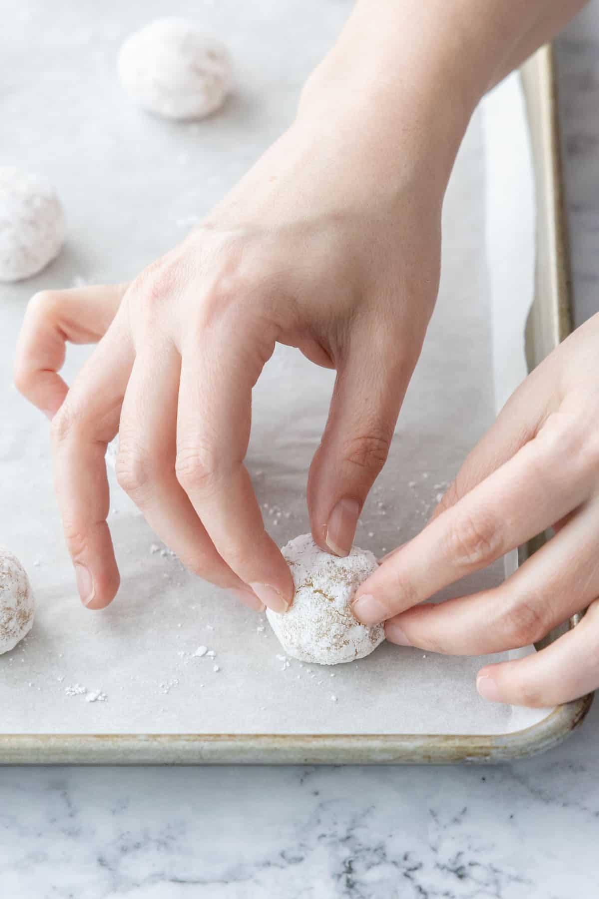 Lightly squeezing the dried-out balls of dough to encourage cracking.