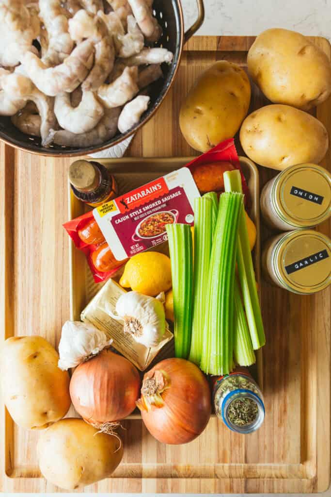 ingredients for a zatarain's shrimp boil arranged on a cutting board.