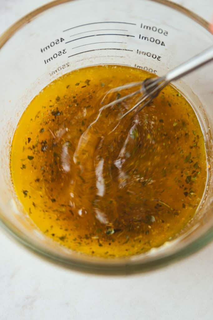 Herbed garlic butter whisked in a measuring cup for shrimp boil. 