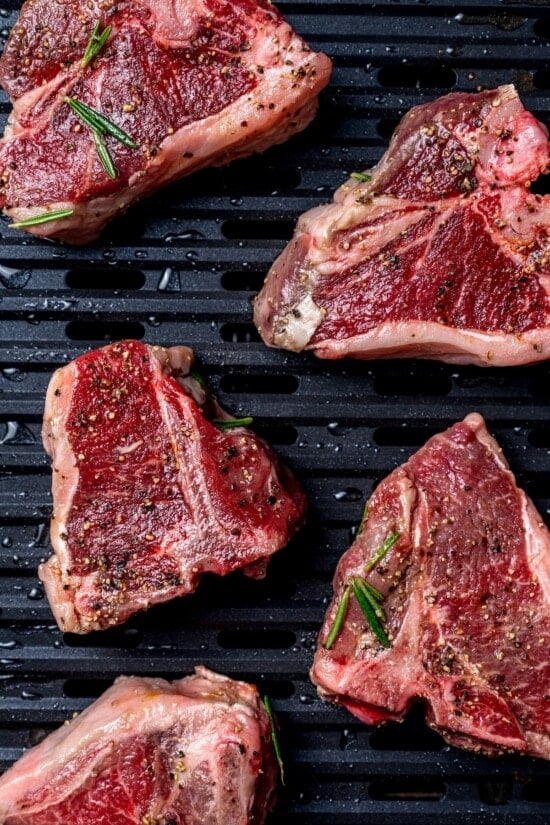 With fragrant rosemary and garlic, this easy grilled lamb chops recipe is flavorful, succulent, and one I love to cook all year long! Overhead view of raw lamb chops on grill pan