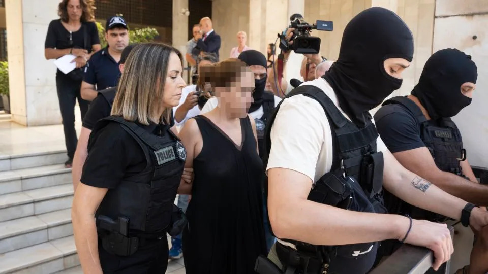 Greek police lead the ex-wife of murdered UC Berkeley professor Przemyslaw Jeziorski to court in Athens on Thursday morning, alongside her new boyfriend and three others alleged to be involved in the Polish educator's shooting on July 4. CNN has added blur to this image. - CNN Greece