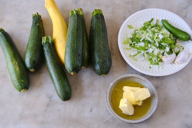 ingredients to make zucchini butter arranged on a marble counter